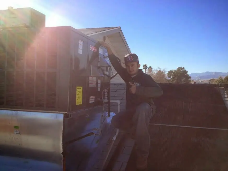 HVAC technician performing HVAC Inspection on a rooftop unit in Eastham